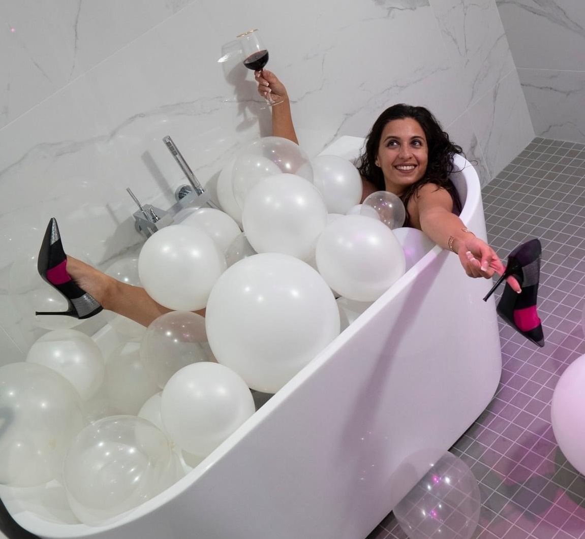 a woman in a bathtub with balloons